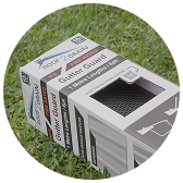 A box of Roof2Drain gutter guards for debris protection placed on green grass