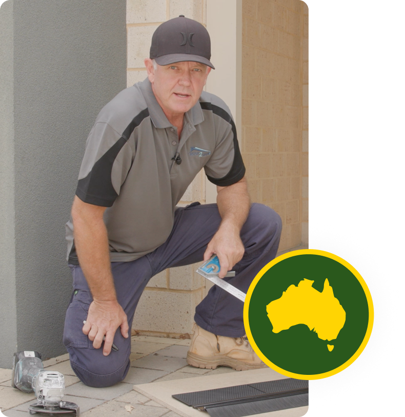 A man wearing a grey shirt and hat installing a Roof2Drain gutter guard for debris protection