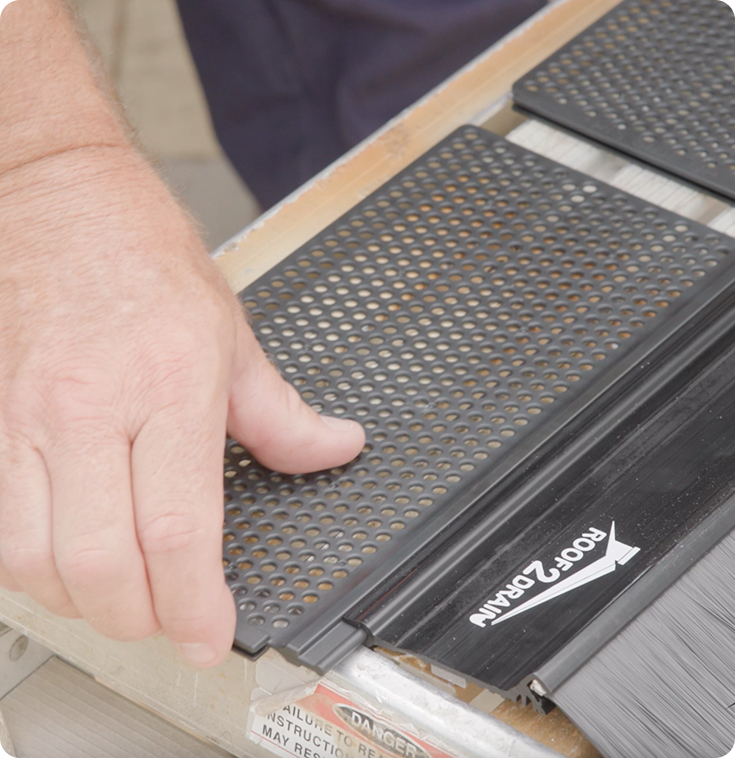 A person installing a Roof2Drain gutter guard for debris protection
