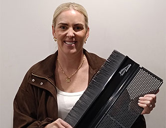Sarah Jenkins holding a gutter guard- Roof2Drain Client