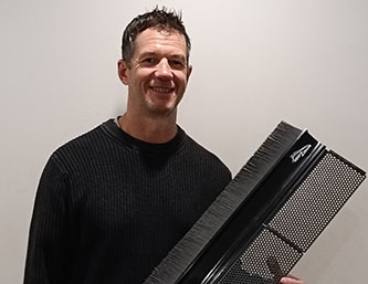 Arthur Pendelton holding a gutter guard- Roof2Drain Client