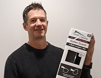 Arthur Pendelton holding a gutter guard- Roof2Drain Client